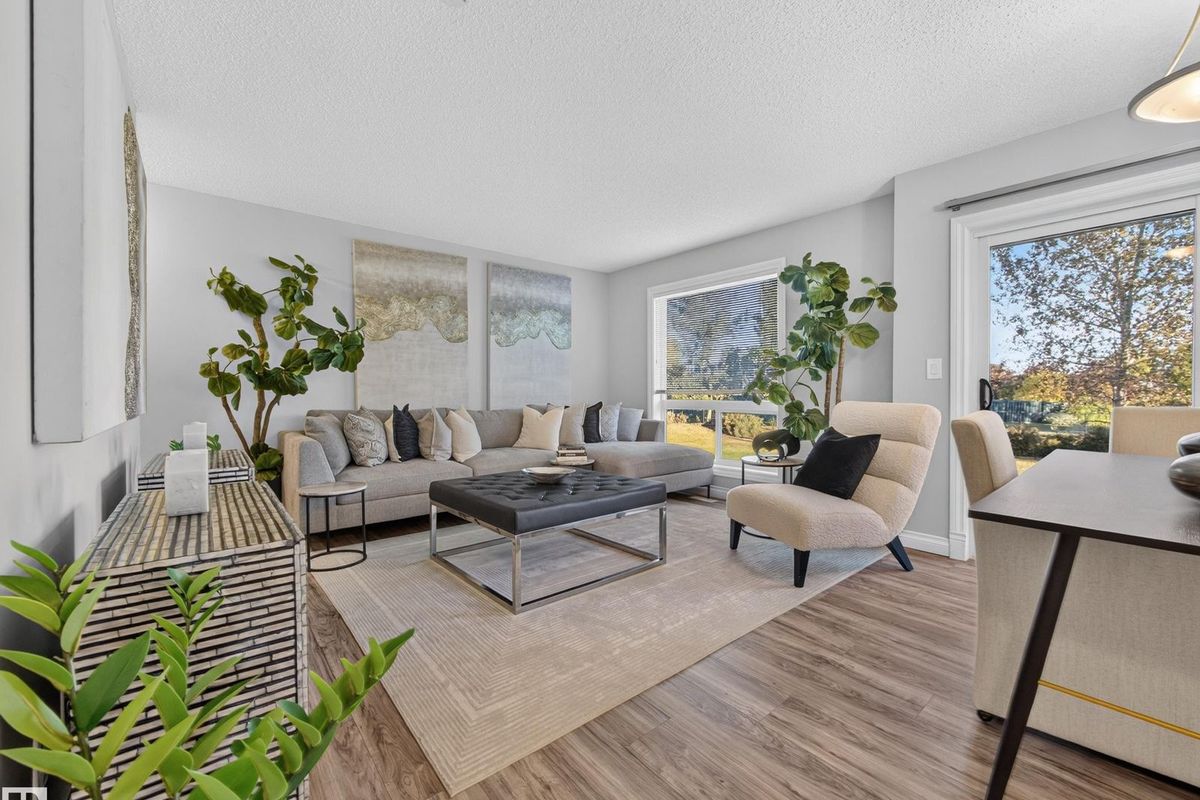 Staged living room with a patio door to the back yard at #44, 12050 17 Avenue SW