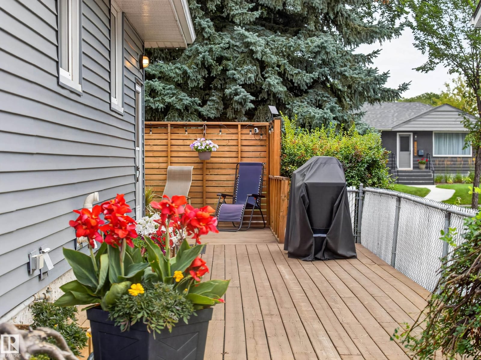 Deck with flower planters and fenced yard beyond