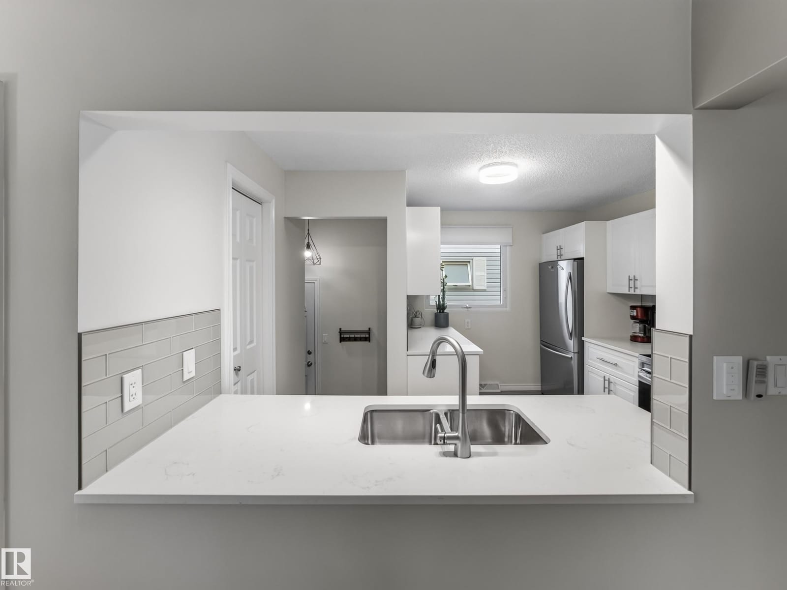 Kitchen peninsula with quartz counter and sink