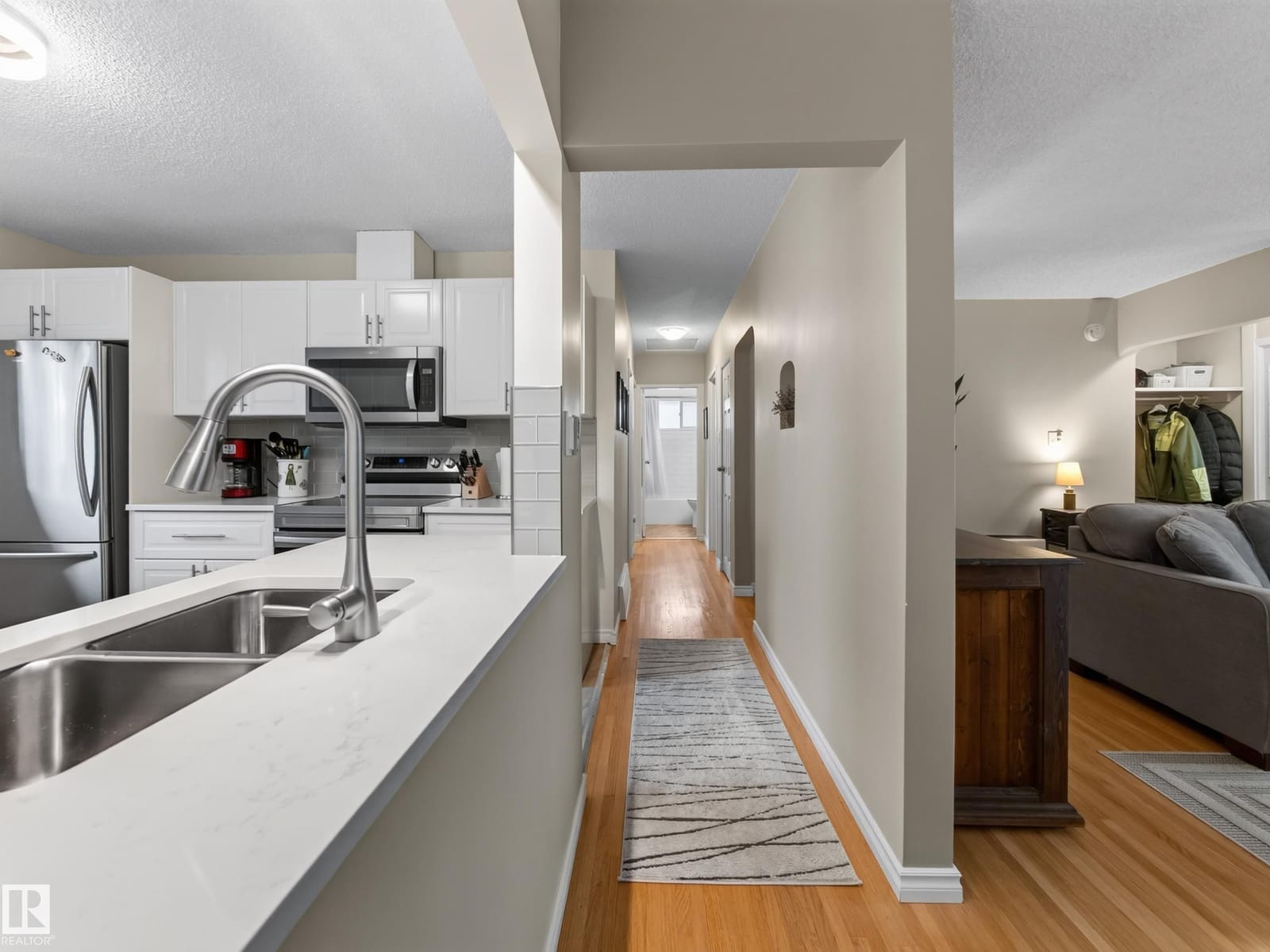 Kitchen with stainless appliances looking down the hall
