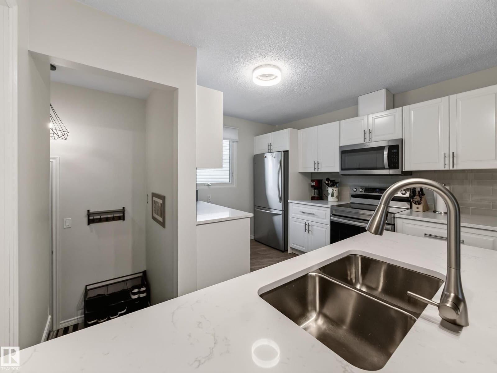 Kitchen with quartz counters and stainless refrigerator