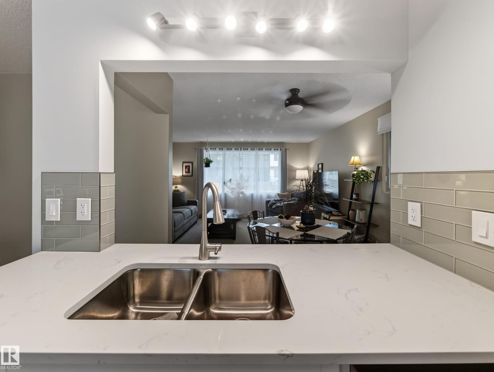 Kitchen peninsula with double sink and sightline to the living room