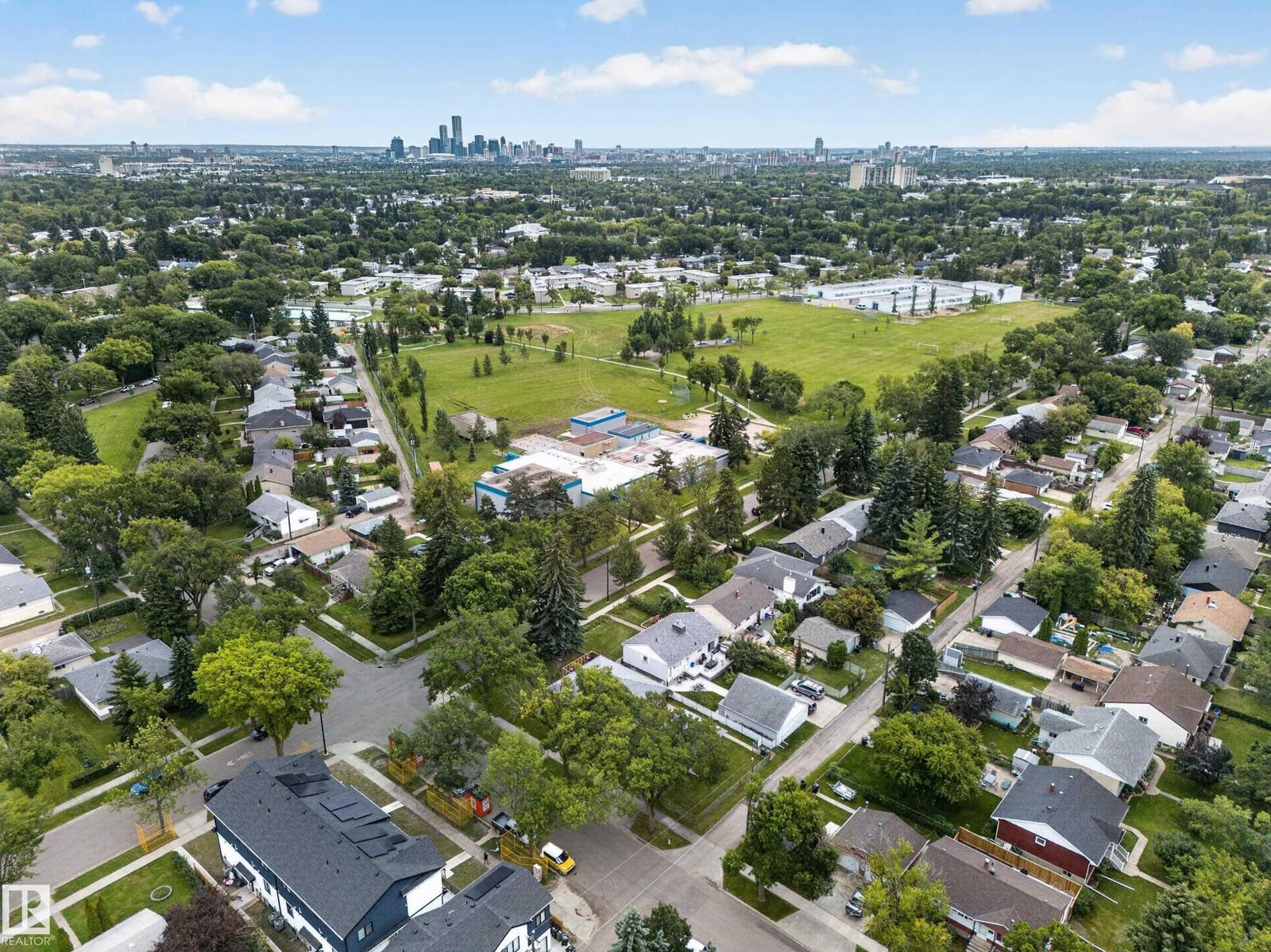 Aerial over the neighbourhood toward the downtown skyline