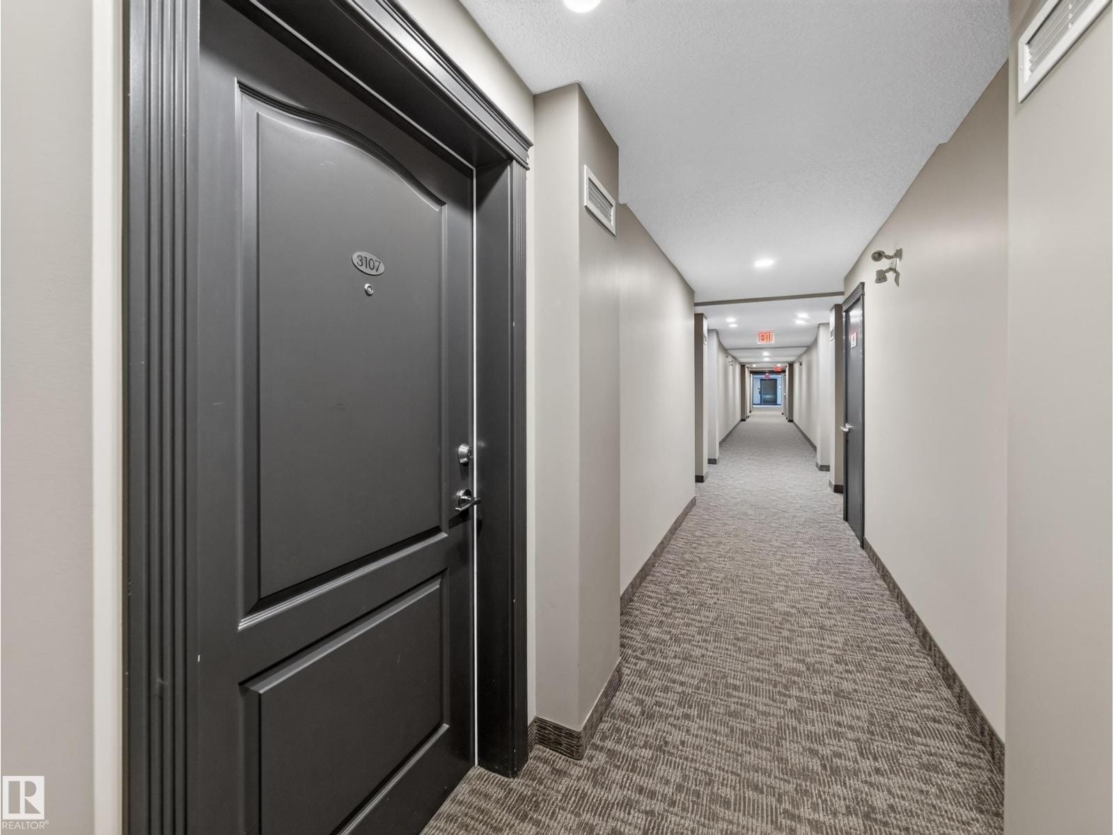 Suite entry door off the carpeted interior corridor