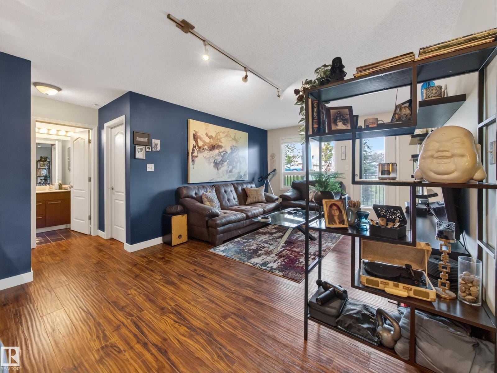 Living space with open shelving and hardwood flooring