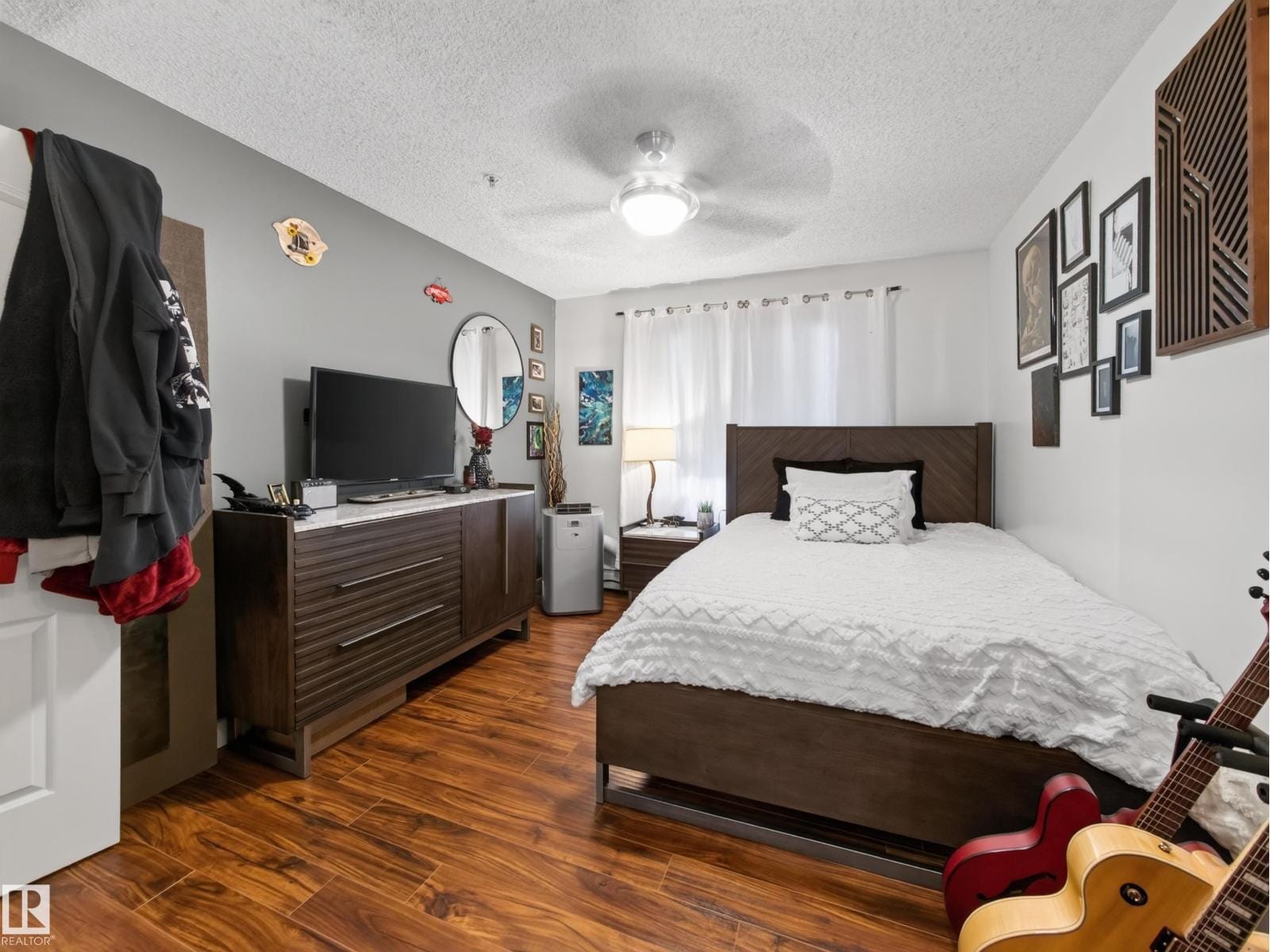 Bedroom with ceiling fan, bed and dresser