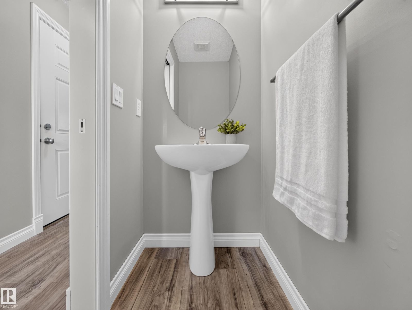 Powder room with oval mirror