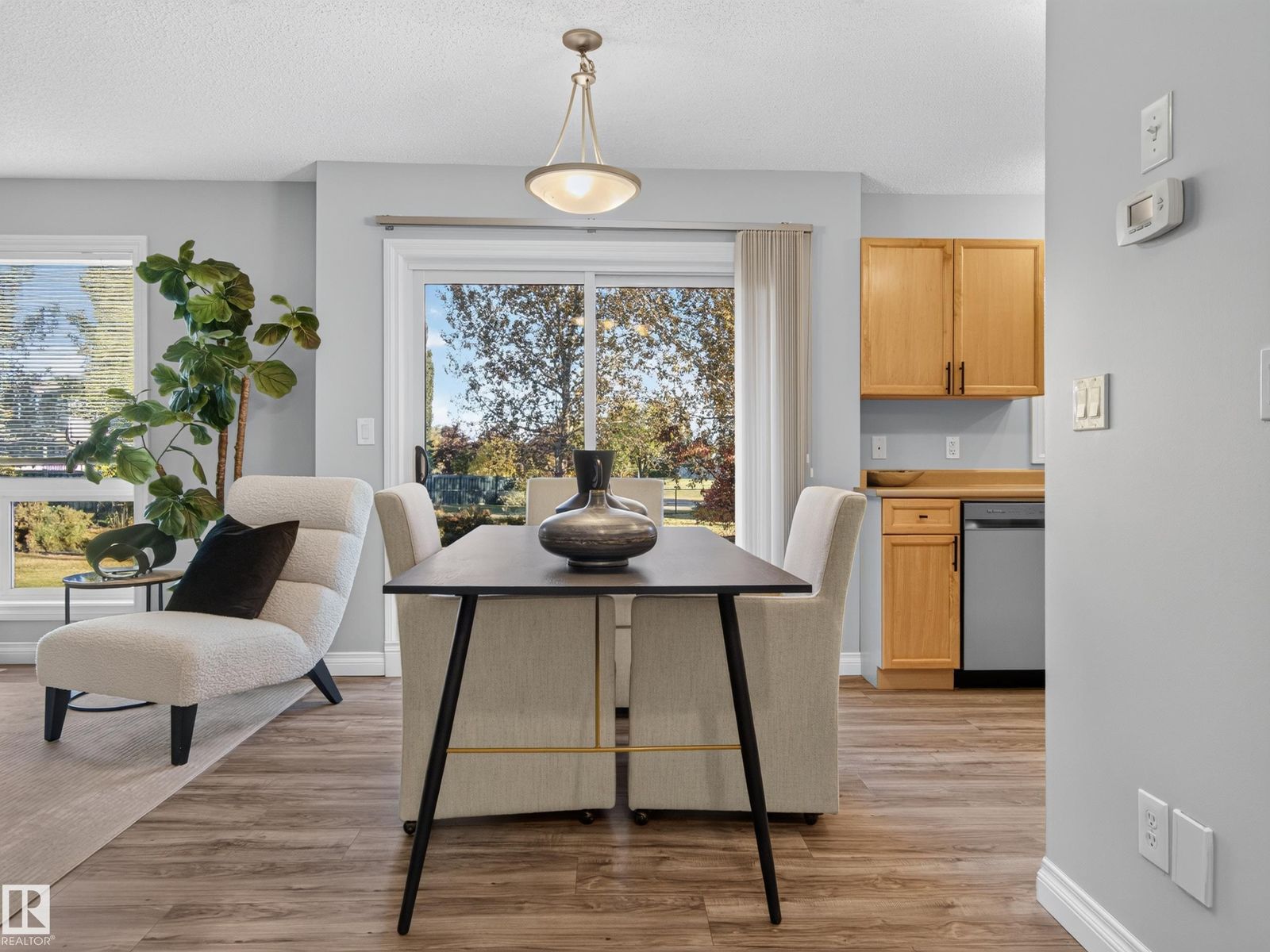 Dining table under the pendant, kitchen beyond