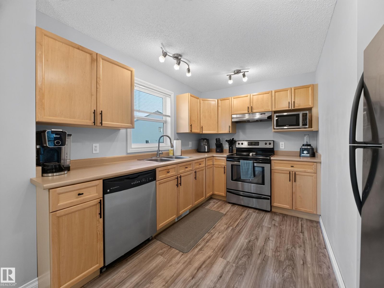 L-shaped kitchen with dishwasher and maple cabinets