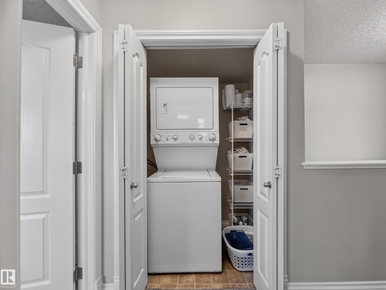 Upstairs laundry closet with stacked washer and dryer