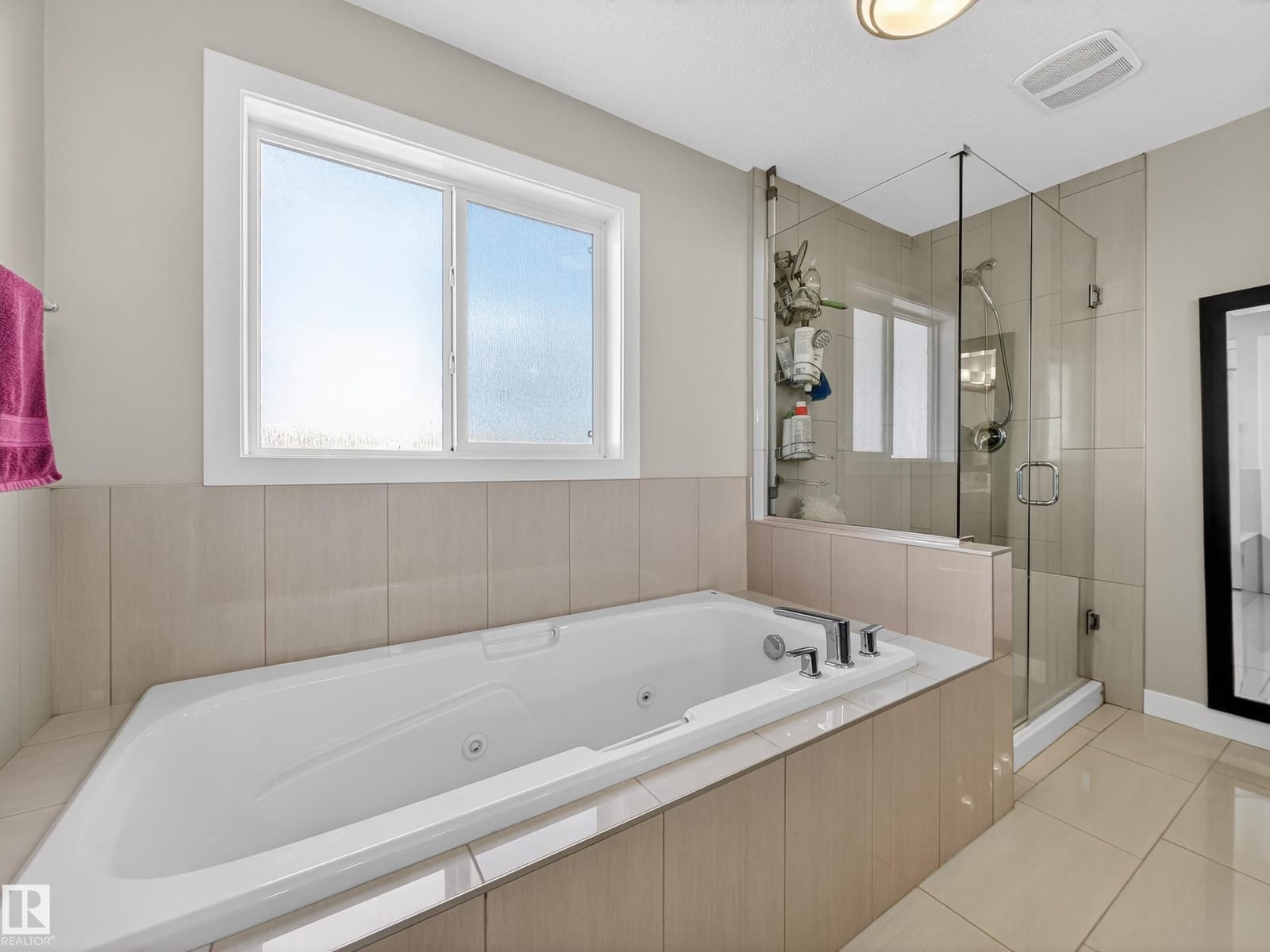 Ensuite whirlpool tub beside the glass shower