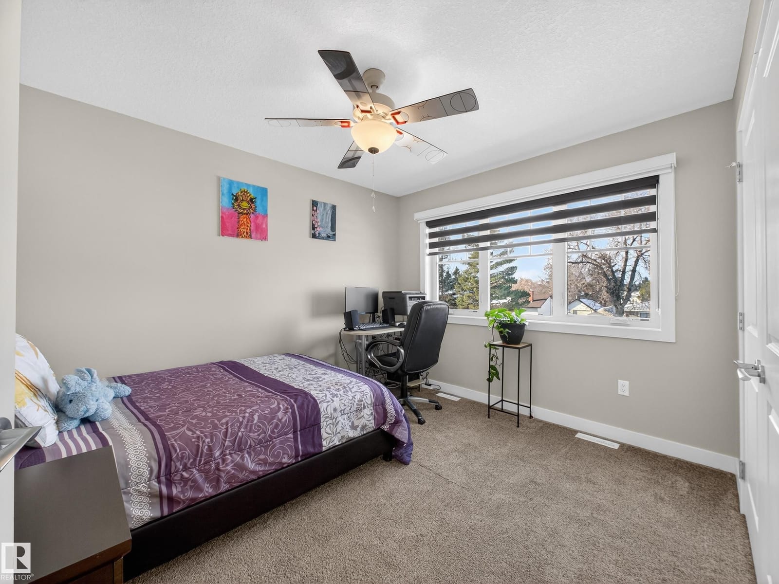Upper-level bedroom with ceiling fan and desk