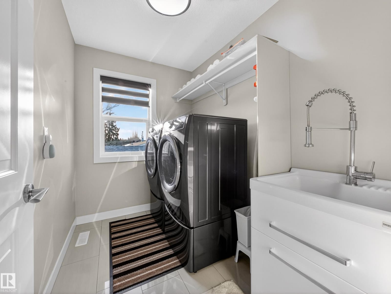 Upper-level laundry with front-load machines and utility sink