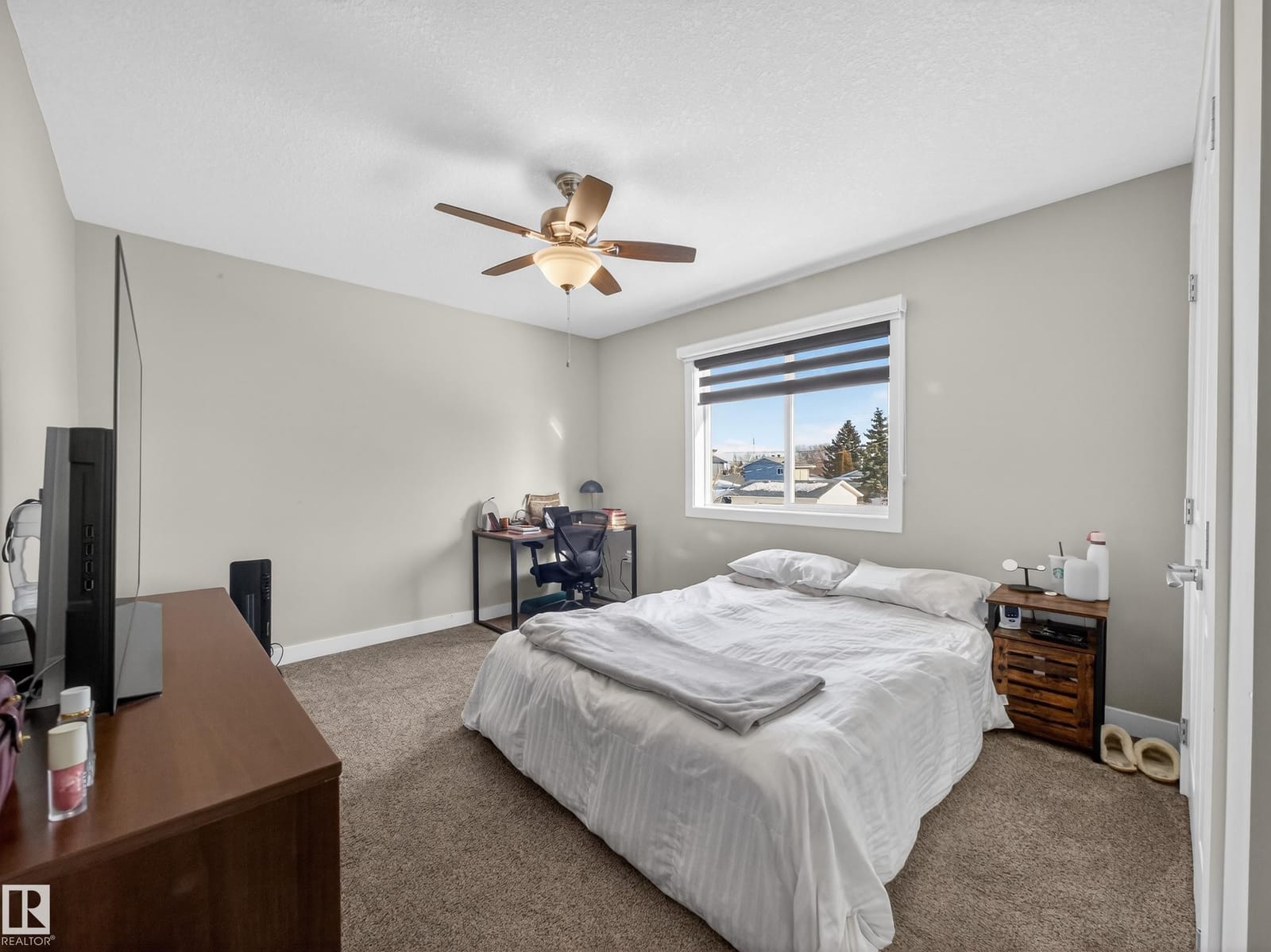 Upper-level bedroom with window and television