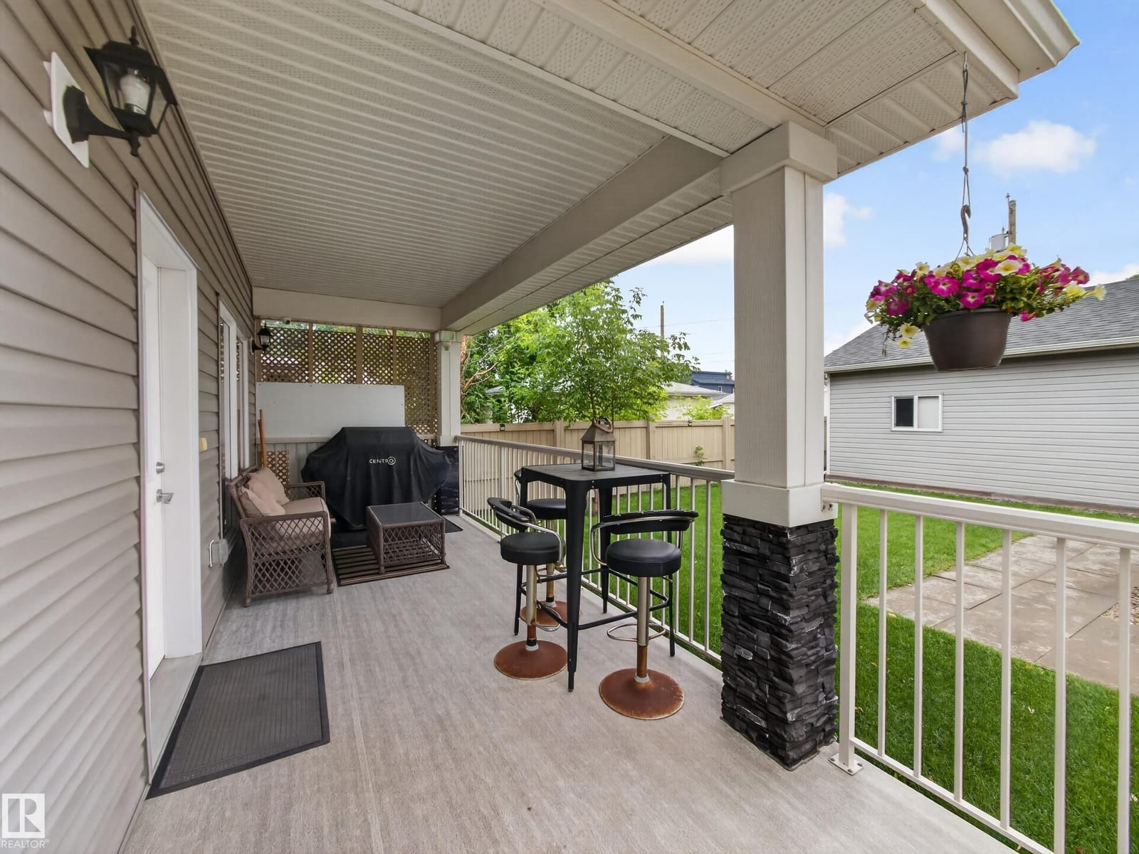 Covered deck with bistro seating and the garage beyond